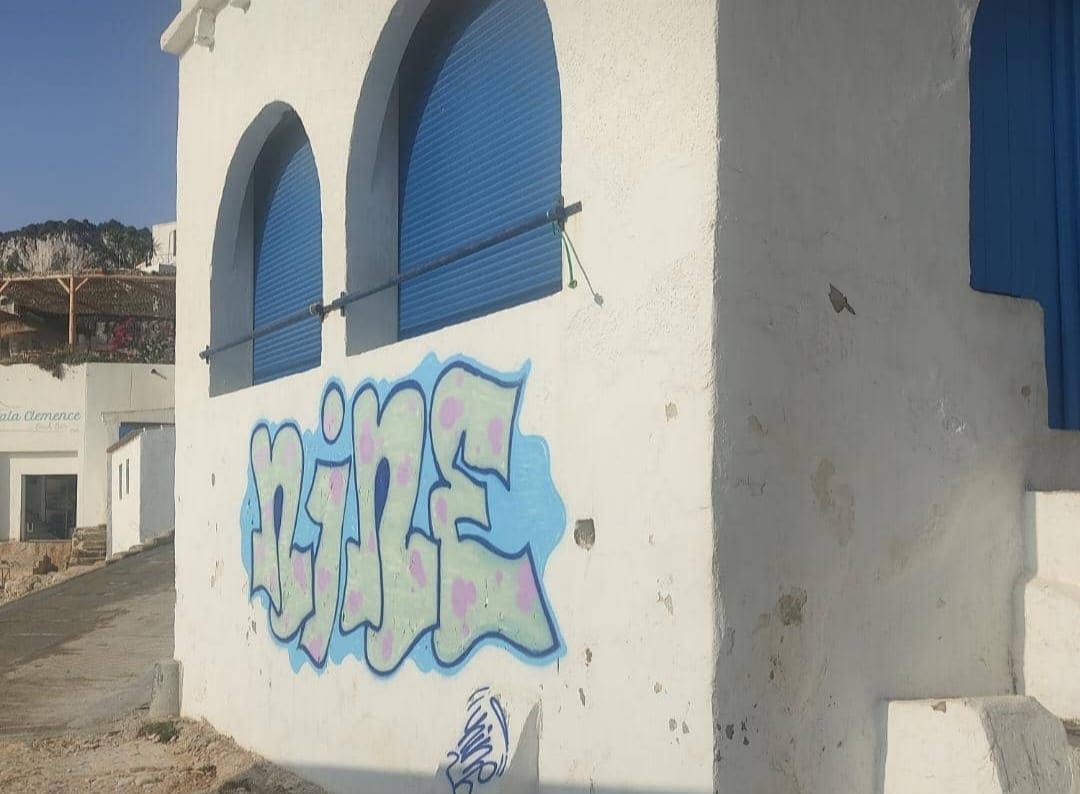 grafiti en la fachada de una de las casas de la cala de la barraca