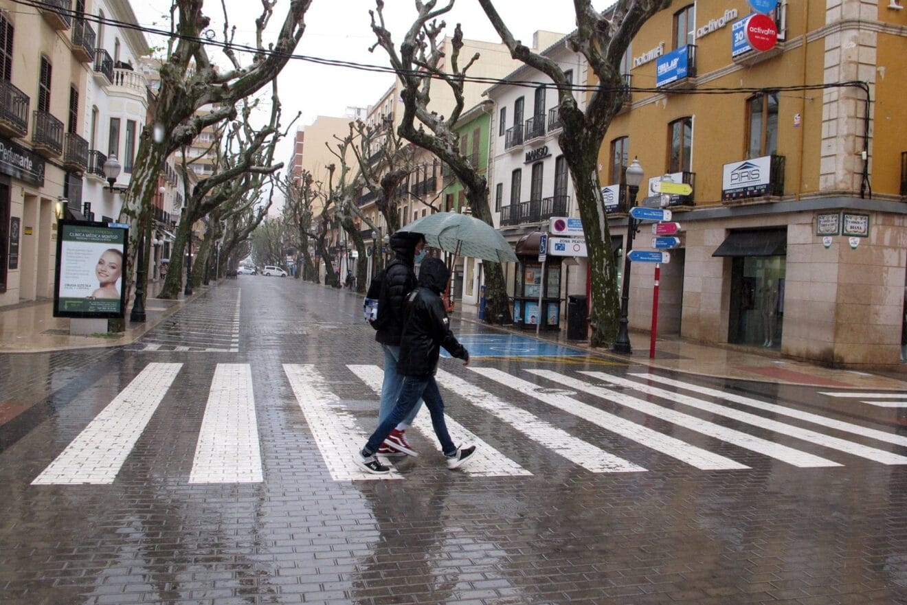 Pareja resguardándose de la lluvia bajo el paraguas en Marqués de Campo