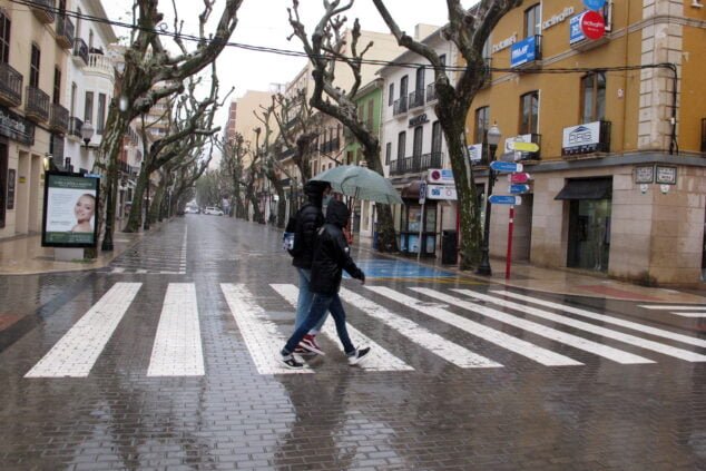 Imagem: Casal se abrigando da chuva sob o guarda-chuva em Marqués de Campo