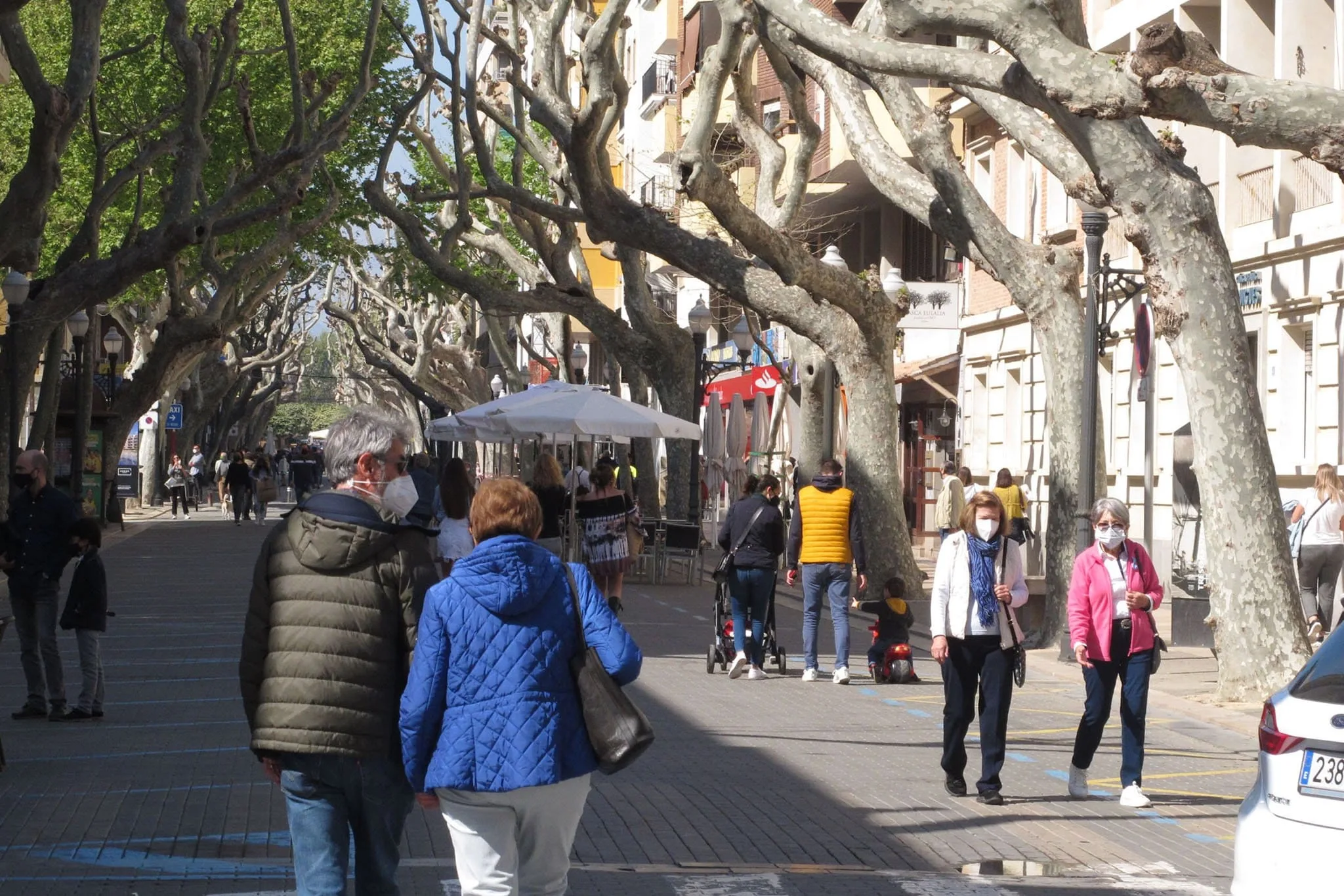 viandantes con mascarilla paseando por el centro de denia