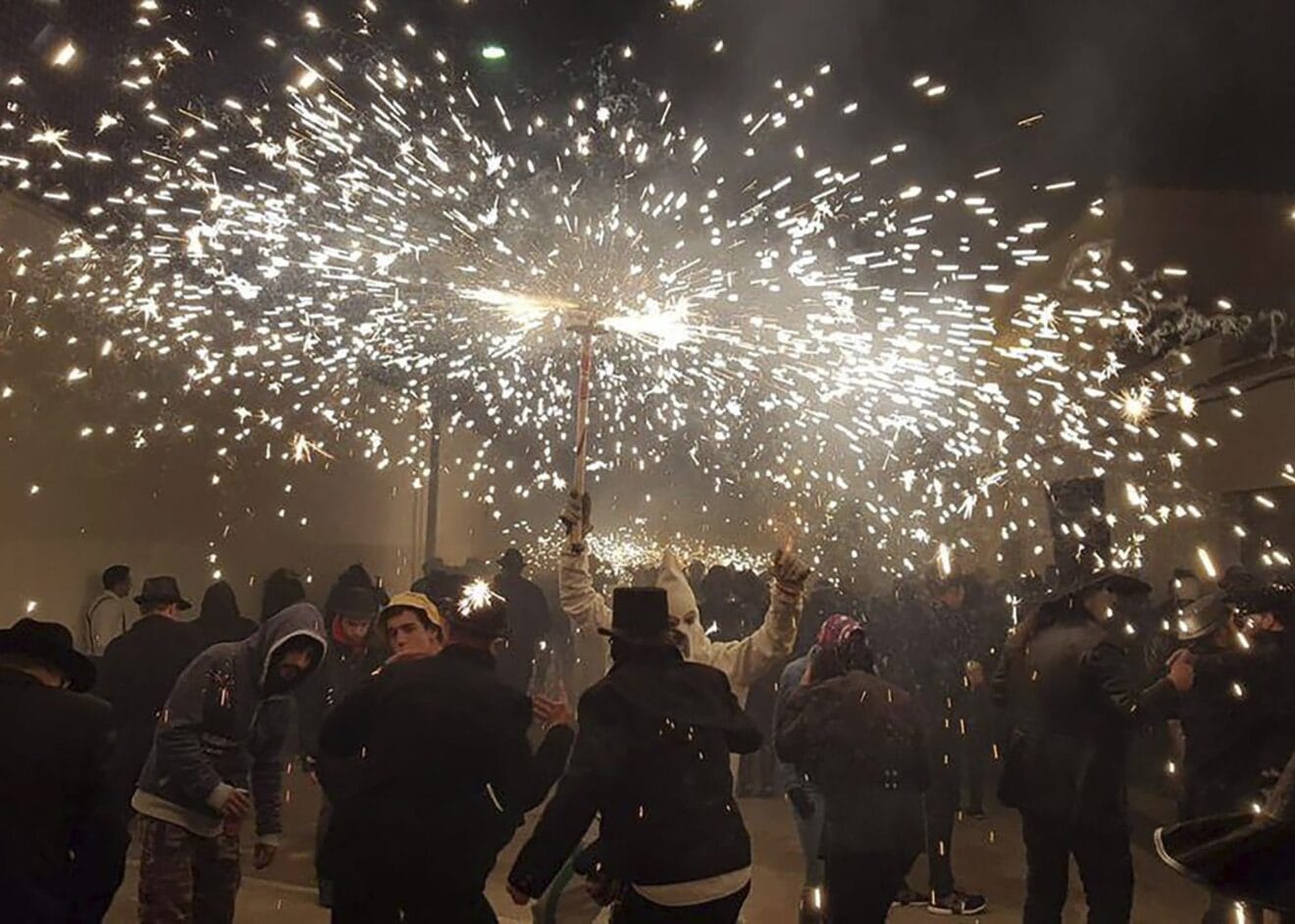 Dimoni y agrupaciones de gente bailando bajo los fuegos