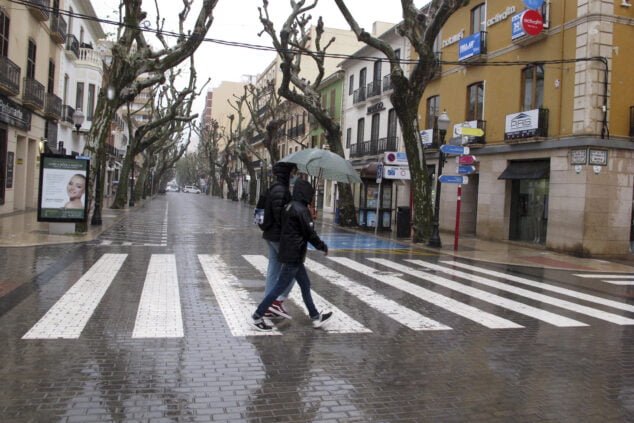 Imagen: Gente paseando en Dénia durante la lluvia