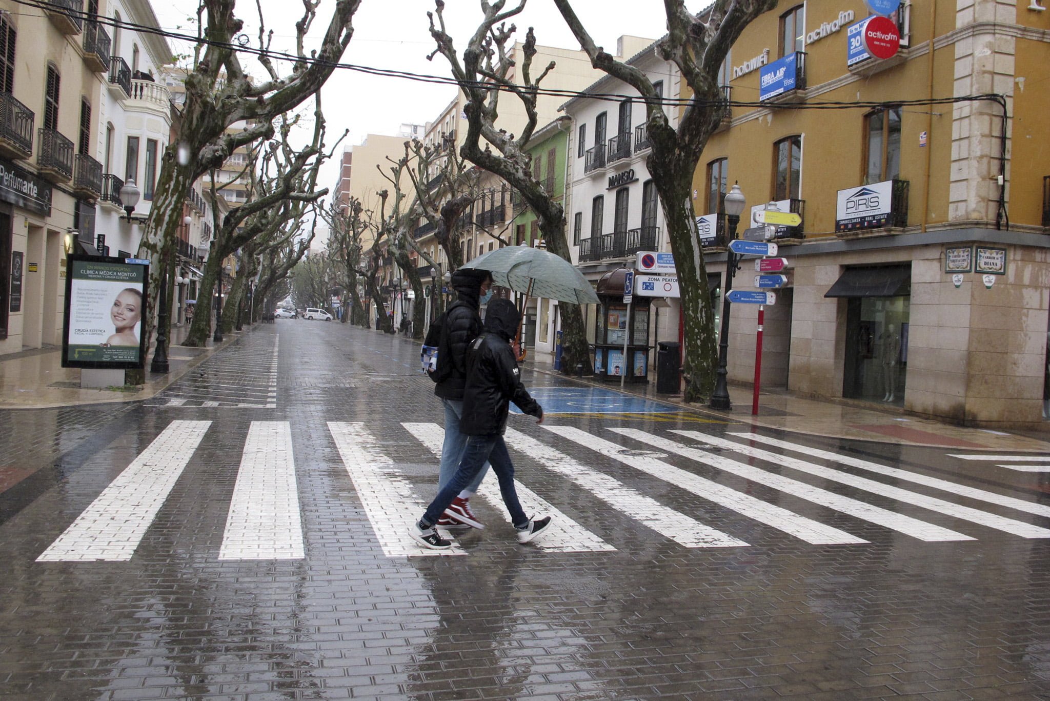 Gente paseando en Dénia durante la lluvia