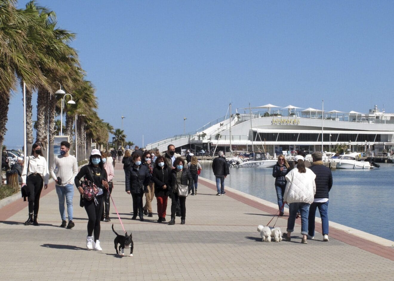 Gente paseando por el puerto de Dénia con mascarillas