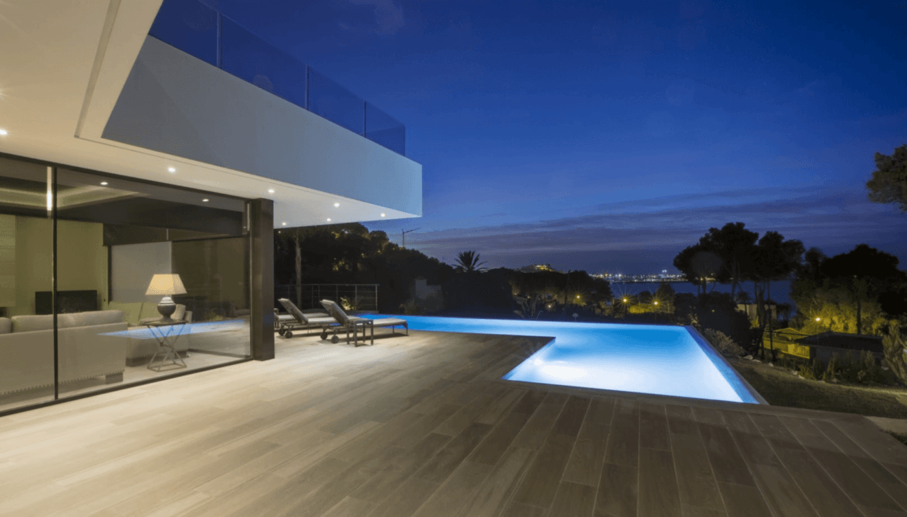 Terraza con piscina iluminada de noche - Urbimed Villas