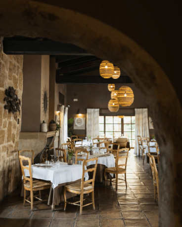 Elegante salón interior de estilo rústico chic con vigas de madera y piedra vista
