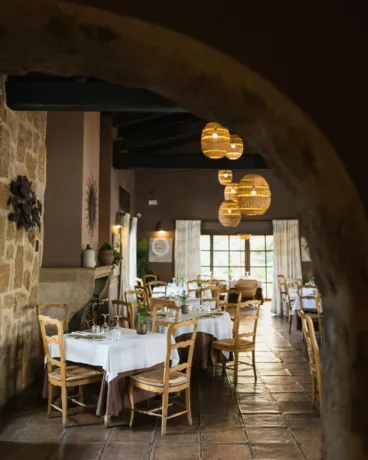 Elegante salón interior de estilo rústico chic con vigas de madera y piedra vista