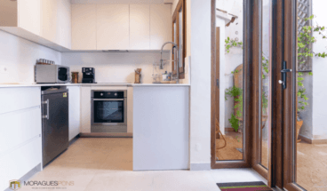 Moderna cocina abierta al salón con acceso al patio