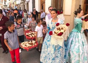 Niños y festeros preparados para repartir los panes