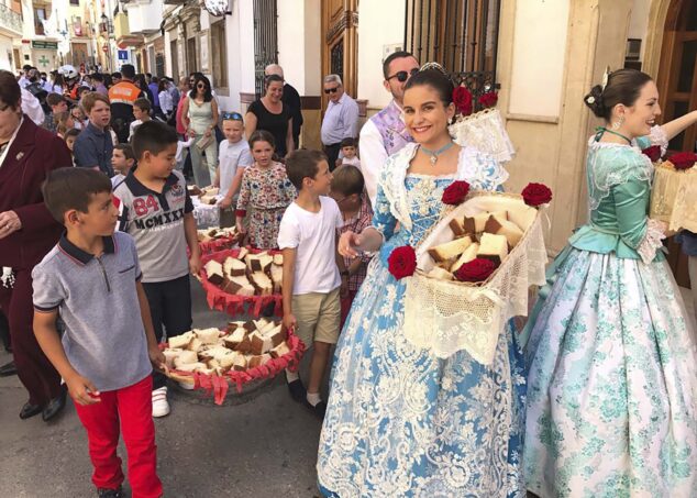 ninos y festeros preparados para repartir los panes