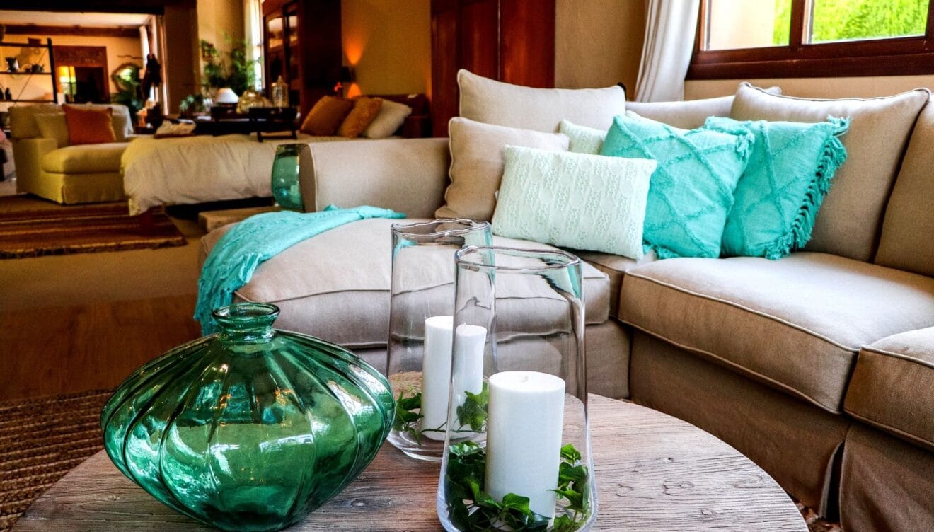 Sofá en tonos claros con accesorios azul turquesa