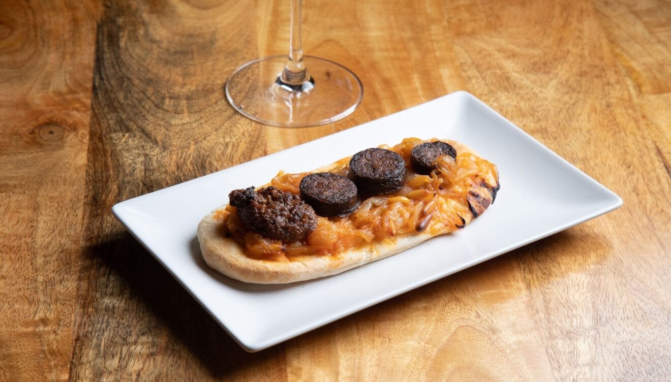 Coca de morcilla, cebolla y champiñones