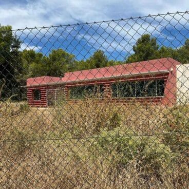 casa roja de calp entre el matorall