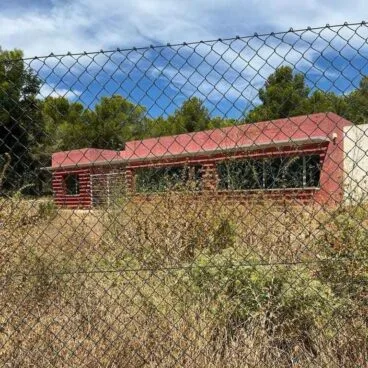 casa roja de calp entre el matorall