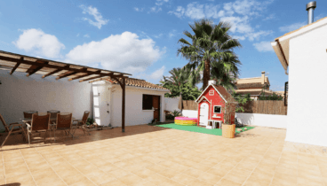 Exterior de la vivienda con pérgola y comedor exterior