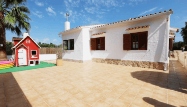 Terraza trasera de la vivienda con casita de juguete