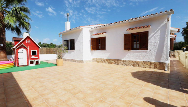 Terraza trasera de la vivienda con casita de juguete