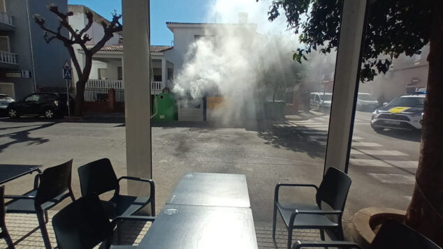 humo en los contenedores de una calle de pego