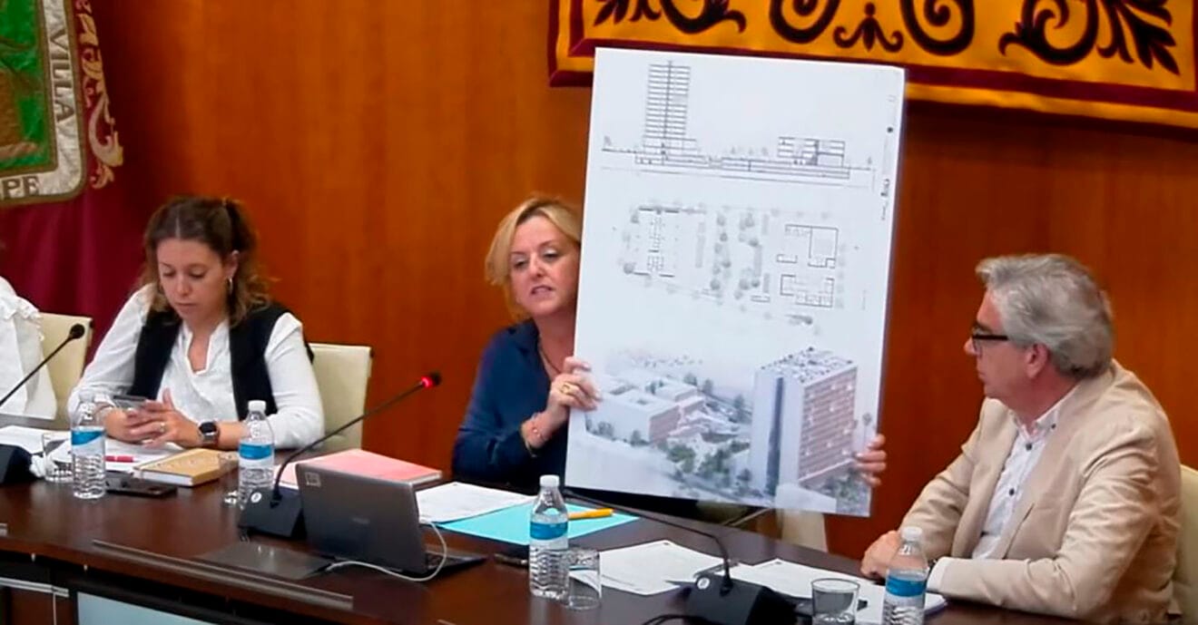 Ana Sala mostrando el póster con el proyecto del complejo inmobiliario en el pleno de mayo 2023