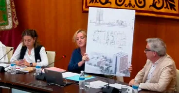 ana sala mostrando el poster con el proyecto del complejo inmobiliario en el pleno de mayo 2023