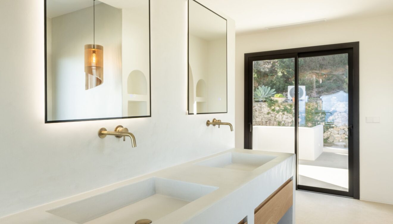 Reforma de baño moderno con diseño actual, iluminación integrada y materiales premium por Juan Vilar Construcciones
