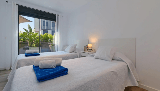 dormitorio con camas individuales con acceso al exterior