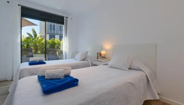 dormitorio con camas individuales con acceso al exterior