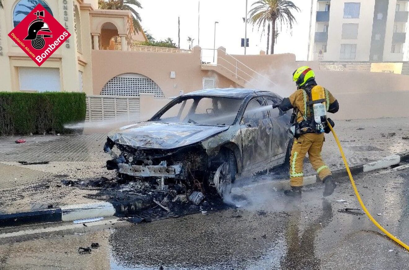 Bombero apagando el coche accidentado en Calp