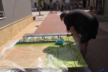 Artista de ‘Persianes amb art’ en la plaça del Castell de Els Poblets