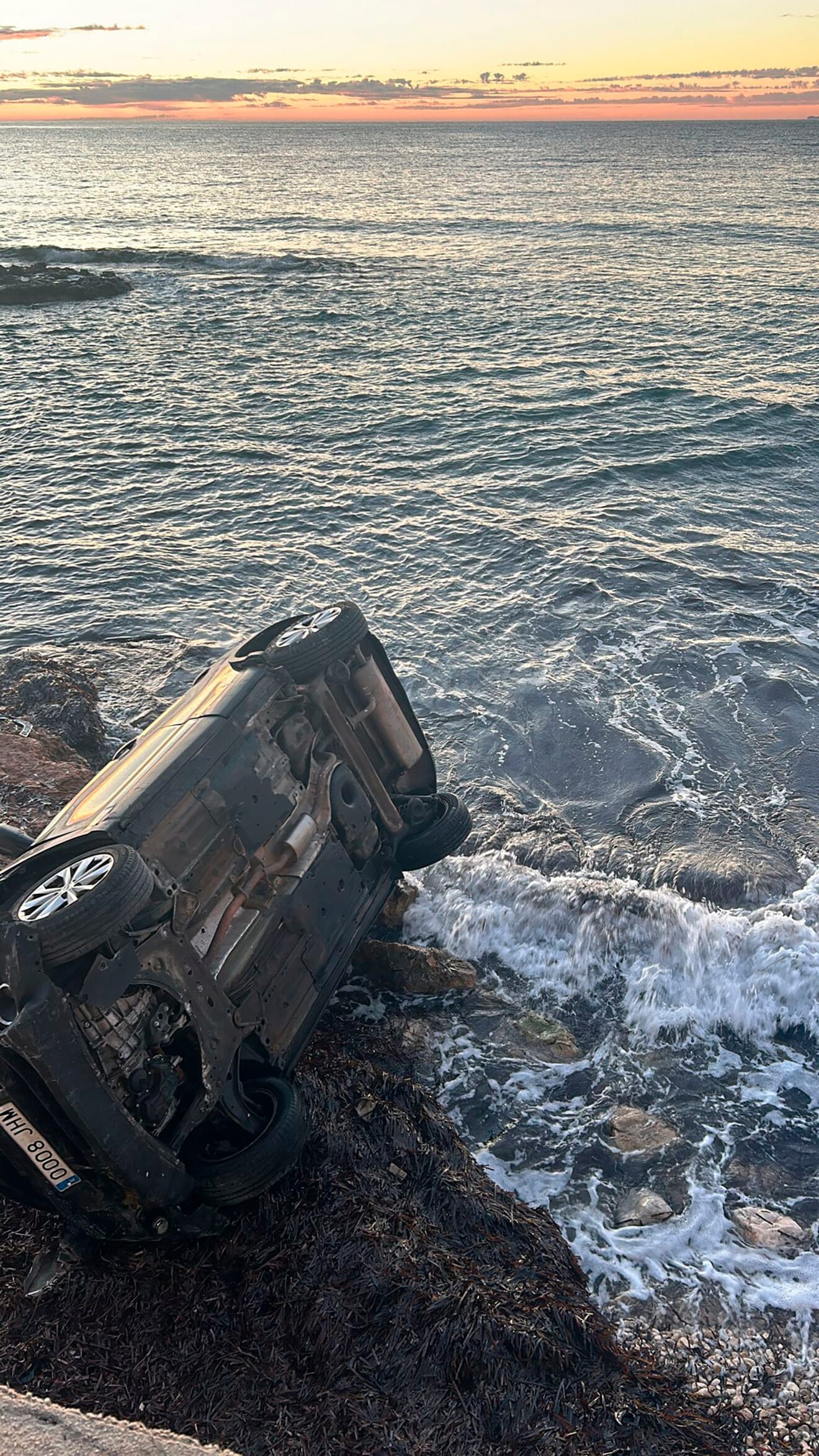 El coche volcado frente al mar
