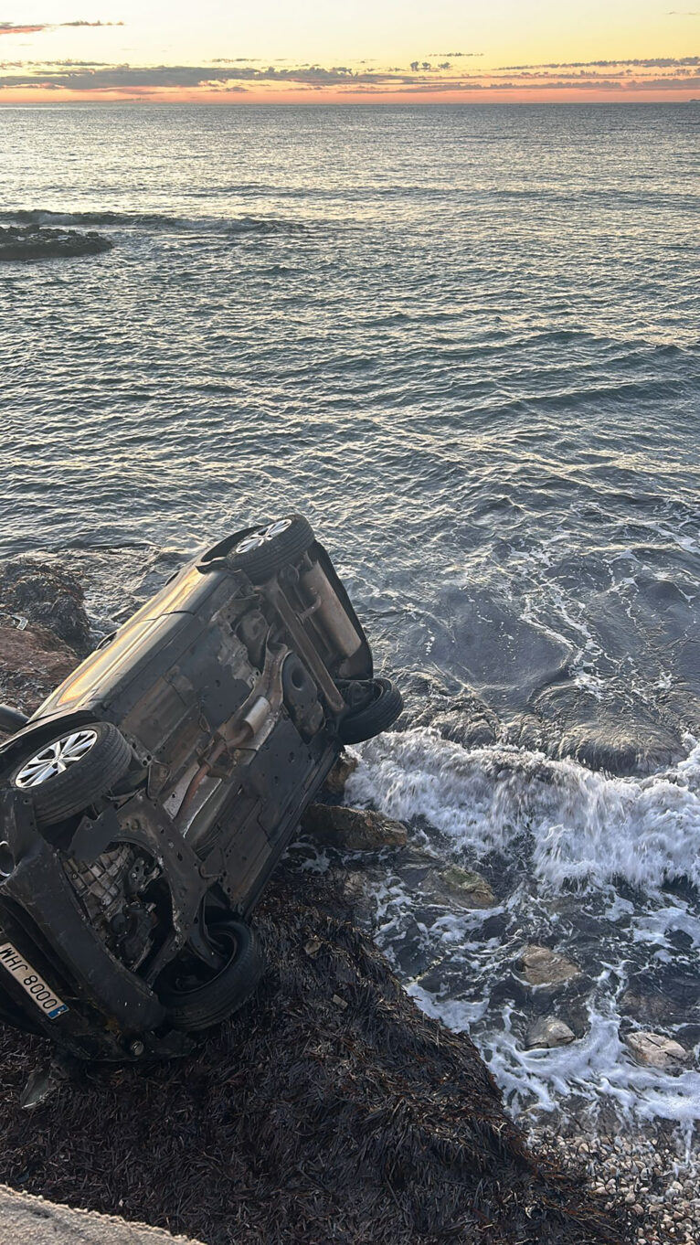 El coche volcado frente al mar