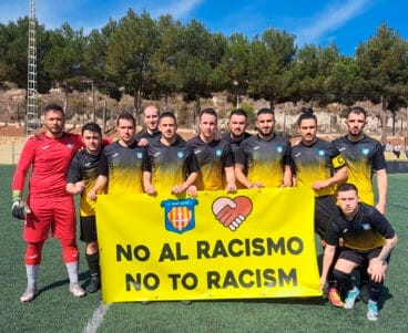 Equipo del C.F. Benitatxell con una pancarta en conmemoración del Día Internacional de la Eliminación de la Discriminación Racial