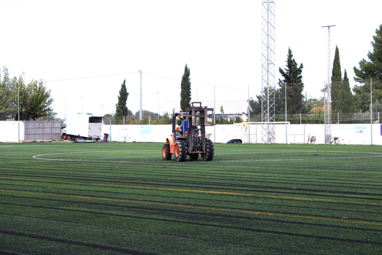 Maquinaria sobre el campo de fútbol de Ondara con el césped nuevo
