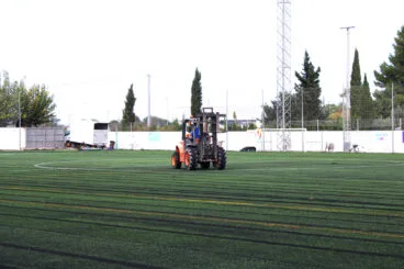 Maquinaria sobre el campo de fútbol de Ondara con el césped nuevo
