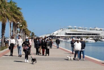 Gente paseando por el puerto de Dénia con mascarilla