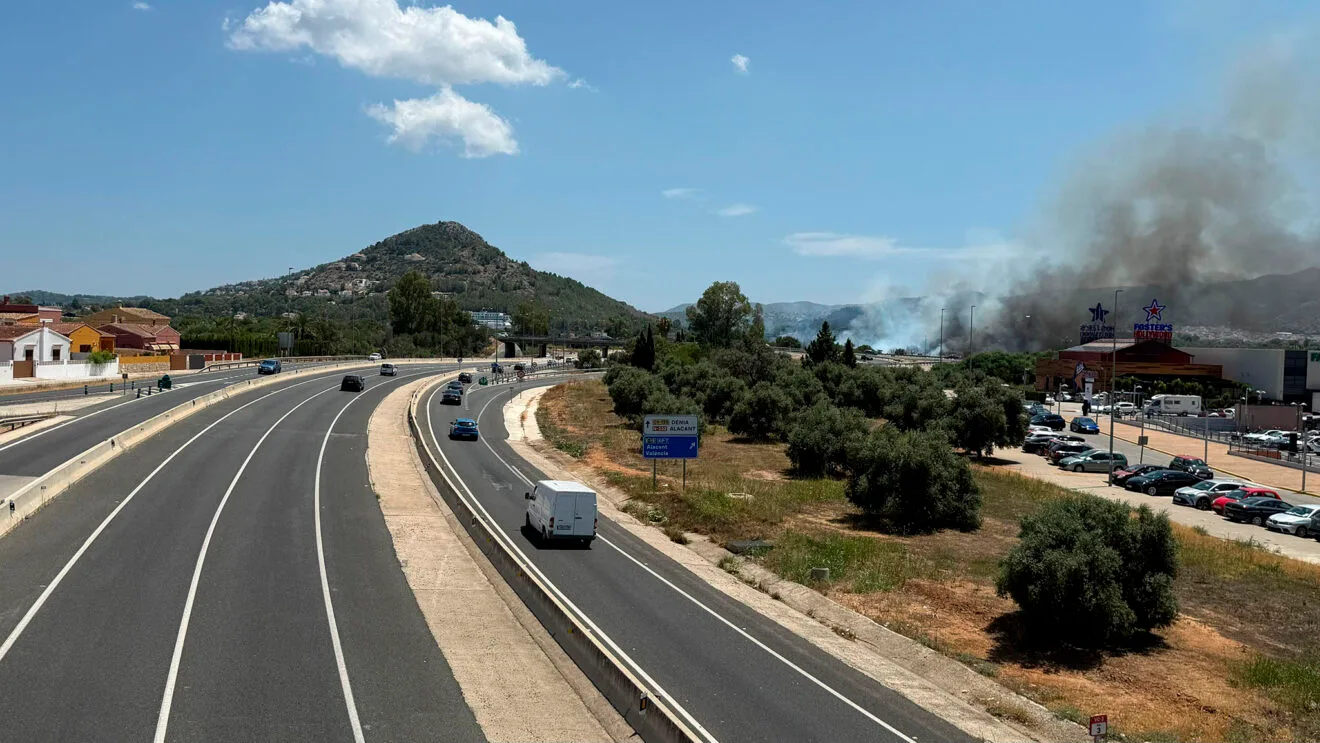 Humo del coche ardiendo junto al centro comercial de Ondara