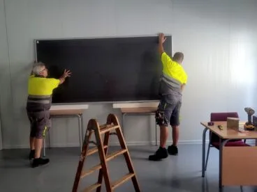 trabajadores colocando una pizarra