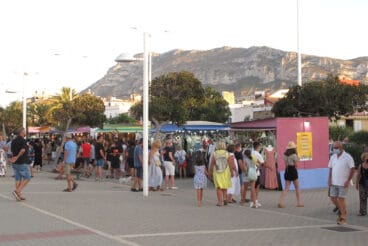 turistas paseando por el puerto de denia