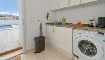 Zona de lavandería equipada practicidad para estancias cómodas y sin complicaciones