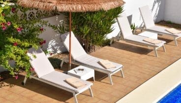 Zona de piscina con tumbonas relax total bajo el clima mediterráneo