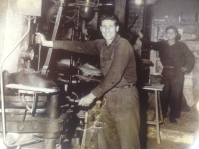 Imagen: Trabajadores en el taller con la máquina de planchar en 1950