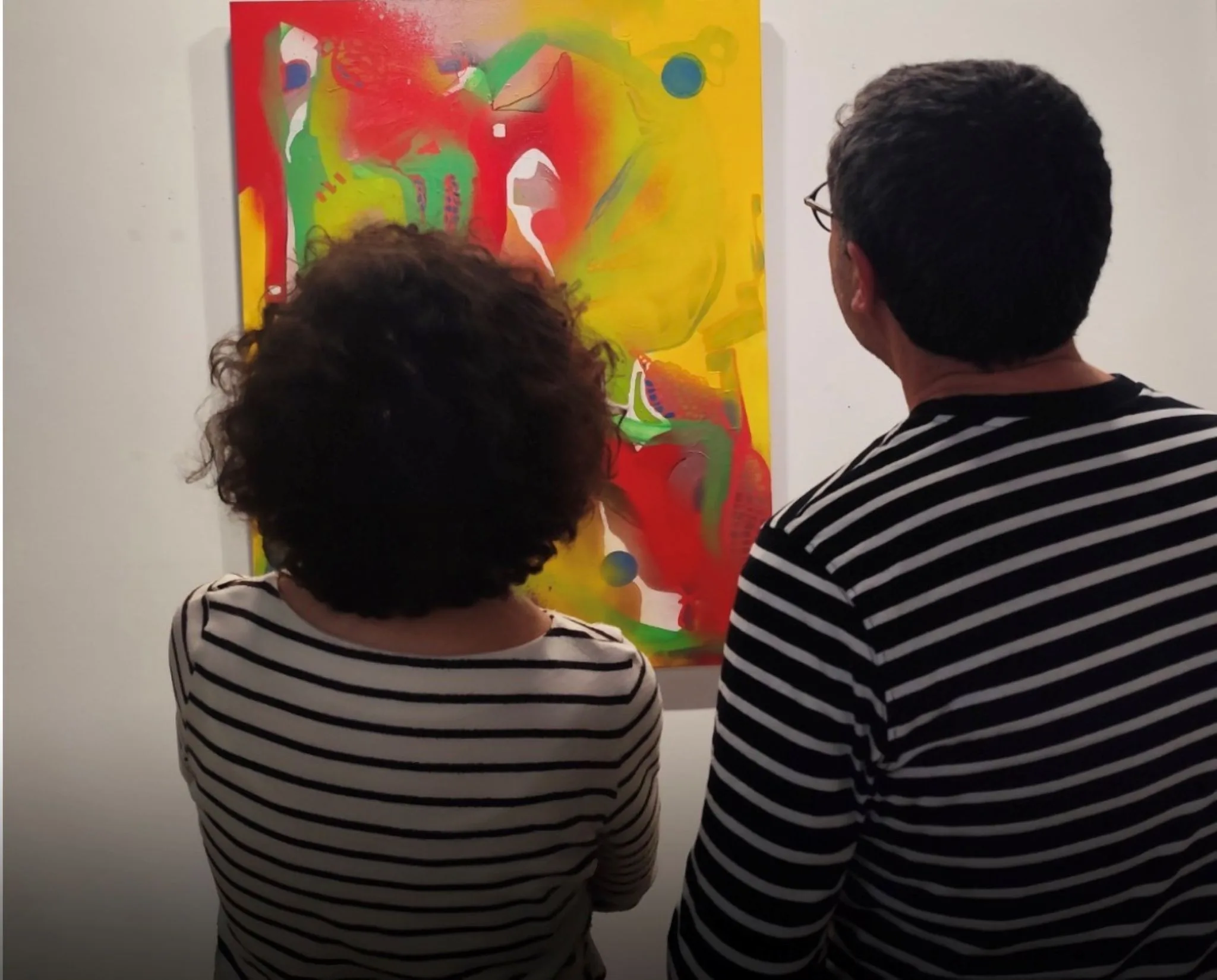 dos visitantes observan una de las obras abstractas de la exposicion beneath the surface