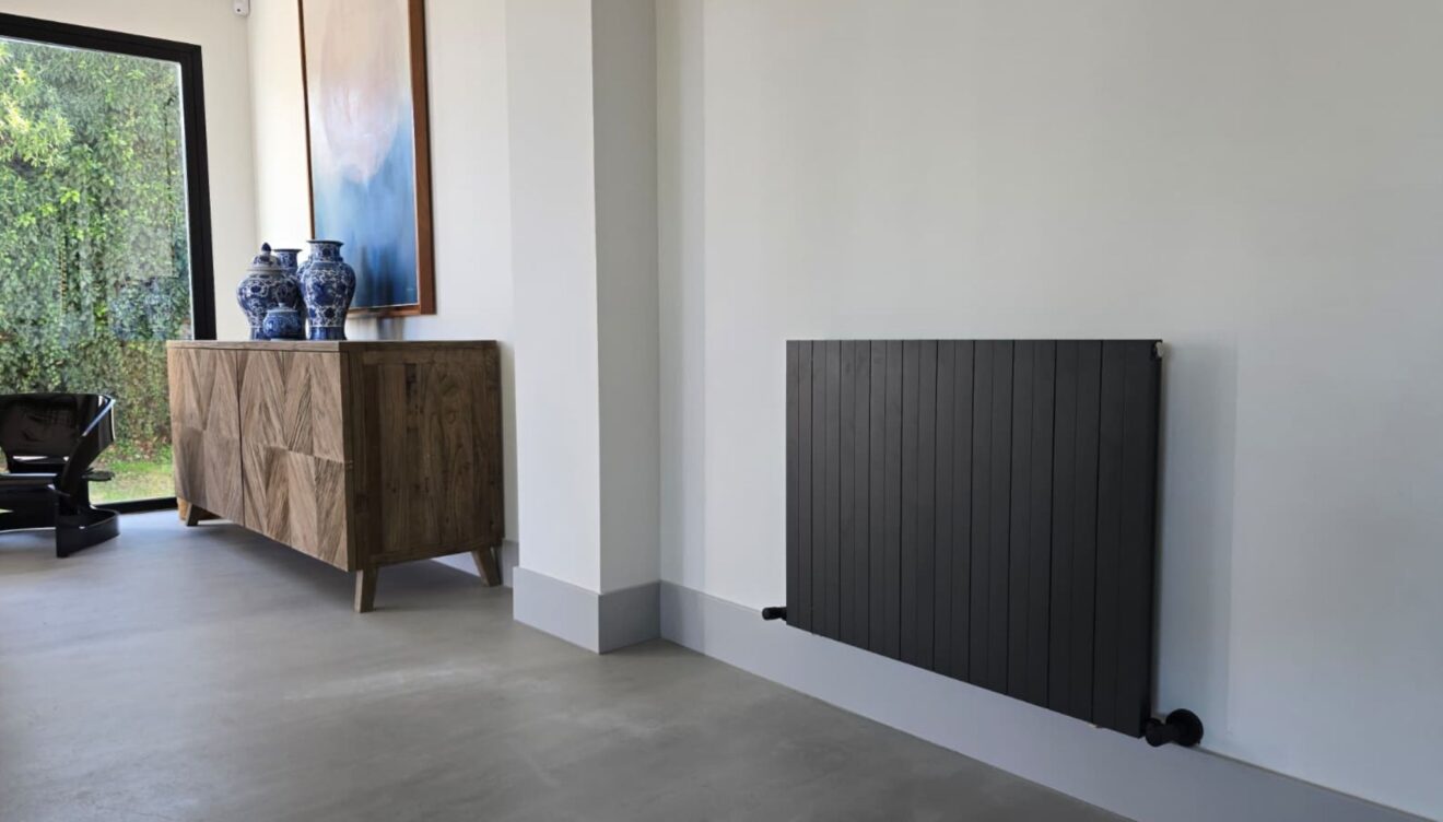 Der horizontale Heizkörper Mithos steht im Mittelpunkt eines modernen Wohnzimmers in der Region Marina Alta.
