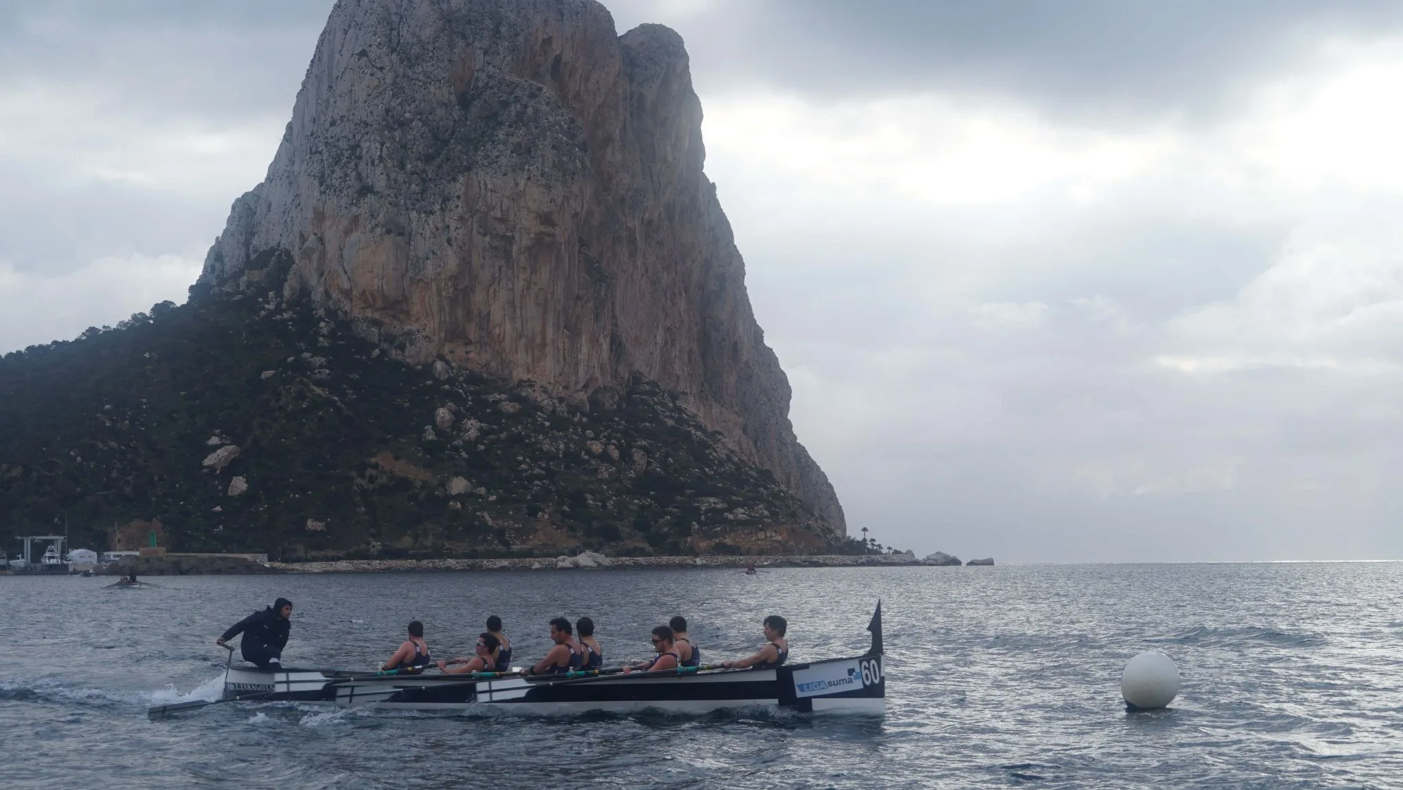 una embarcacion de la liga suma compite frente al penon de ifach durante una regata disputada en aguas de calpe