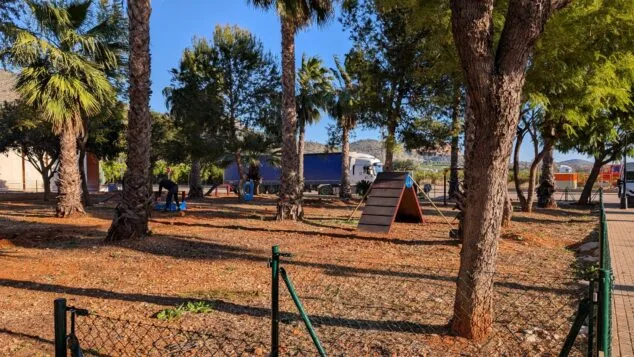 Imagen: Vista general del parque canino, un espacio vallado y arbolado equipado con distintos juegos para las mascotas