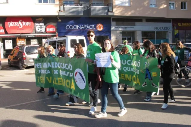 Manifestantes marchan en Dénia tras una pancarta verde que dice "Per una educació pública de qualitat en valencià".
