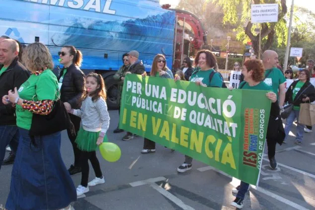 Manifestantes sostienen una gran pancarta por la educación pública y en valenciano durante una protesta en las calles de Denia.