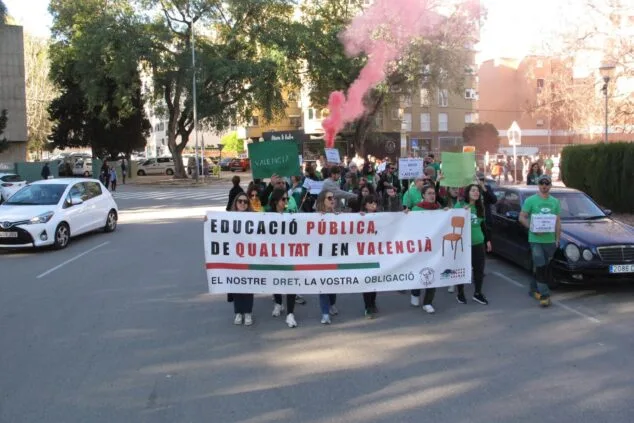 Imagen: Manifestantes con pancarta por la educación pública en valenciano caminan por una calle de Denia