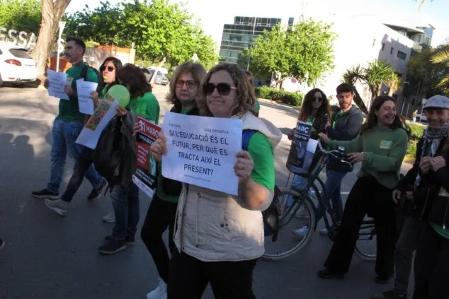 Una manifestante sostiene un cartel que dice "Si l'educació és el futur, per què es tracta així el present?" durante una marcha por la educación pública en Dénia.