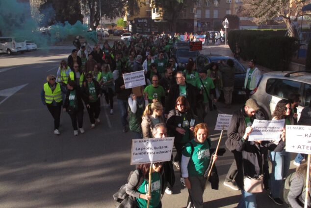 Manifestantes con camisetas verdes y pancartas marchan por una calle durante una protesta por la educación pública en Dénia.